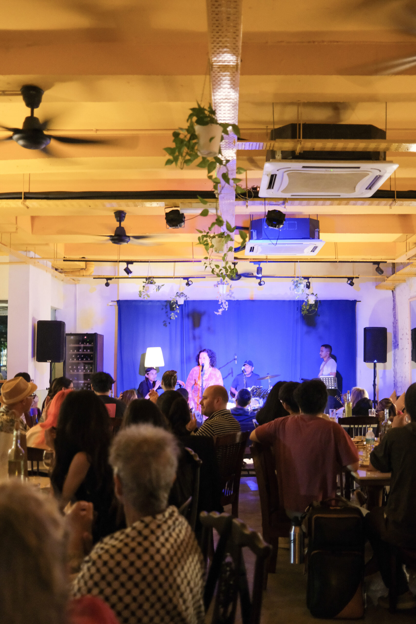 Live music event at Bartolo Lisboa Bakehouse — singer on stage with audience watching
