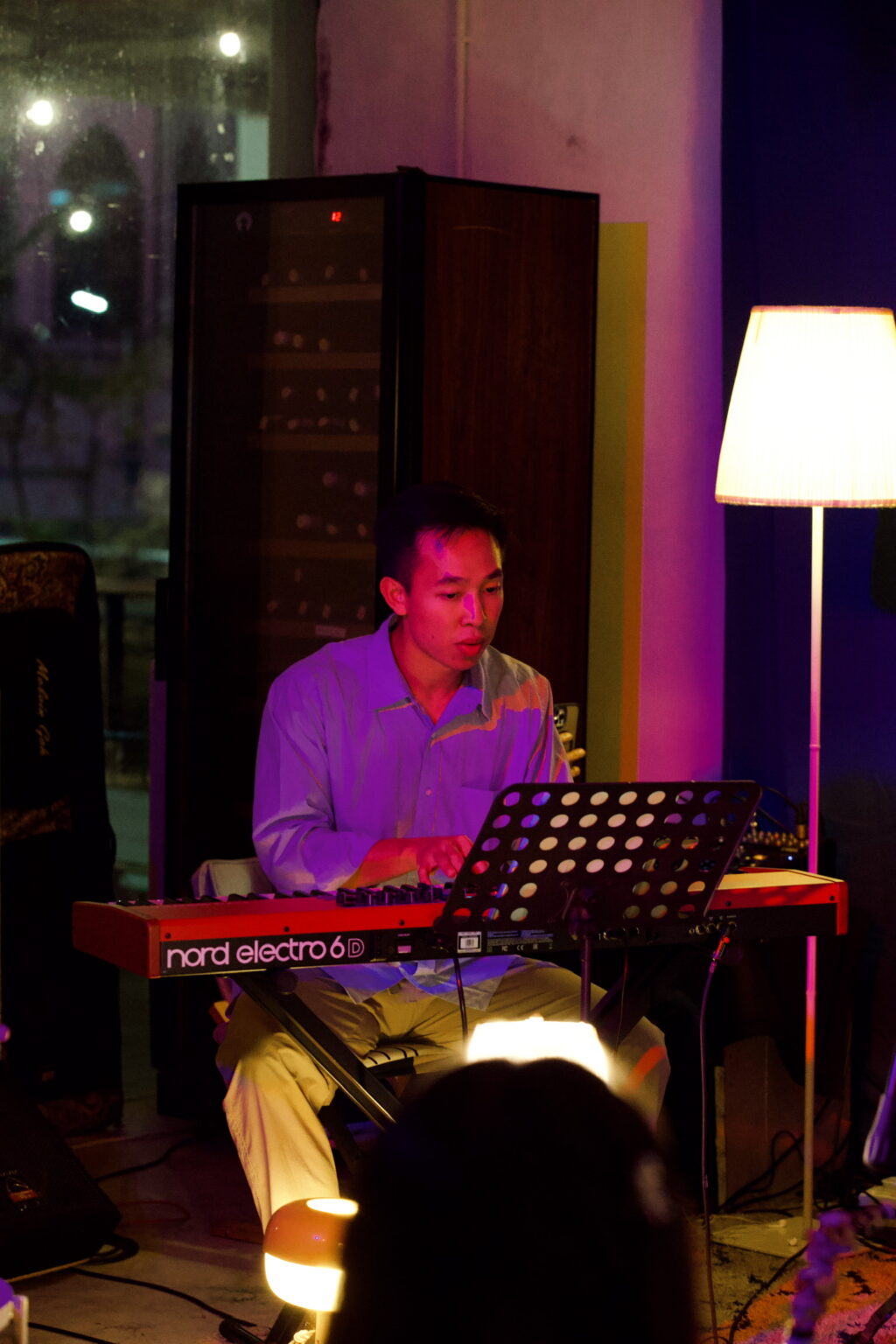 Keyboardist at Bartolo Jazz Jam at night, warm lamp glow